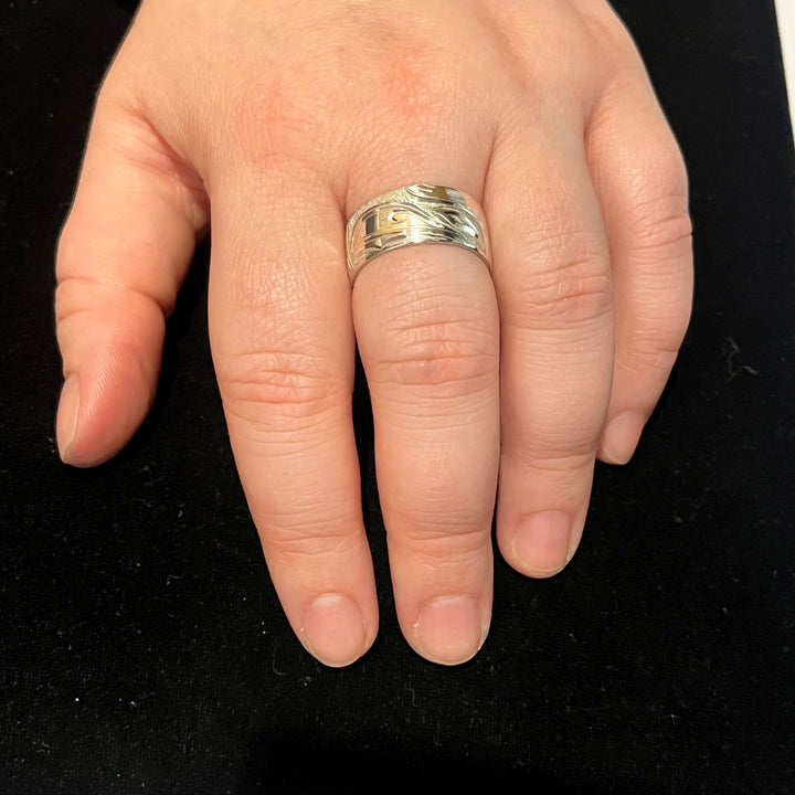 This picture shows the heavy gauge silver Raven ring on a hand.