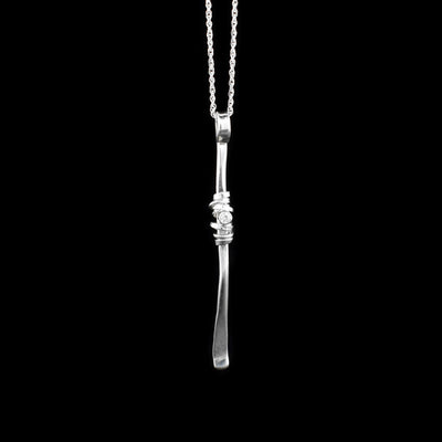 This cubic zirconia necklace is made from sterling silver and cubic zirconia. The pendant is made from a silver "twig" and has an embedded cubic zirconia and silver wrappings in the center of it.