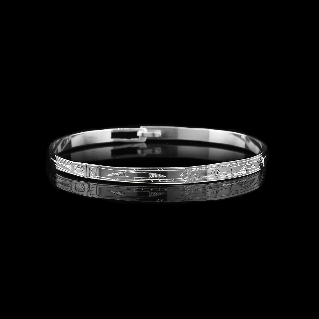 This thin, dainty, sterling silver bangle bracelet is carved with the legend of the orca and the legend of the hummingbird. Their heads meet in the middle of the bracelet