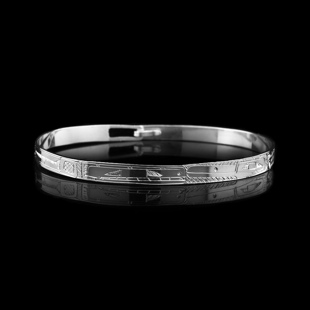 This thin, dainty, sterling silver bangle bracelet is carved with the legend of the orca and the legend of the eagle. Their heads meet in the middle of the bracelet