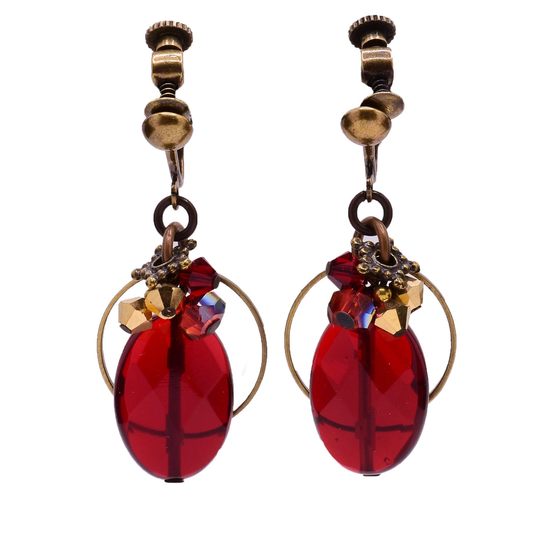 Dangle clip earrings made of handworked brass, Austrian crystal, and glass. Brass clips. By Honica.