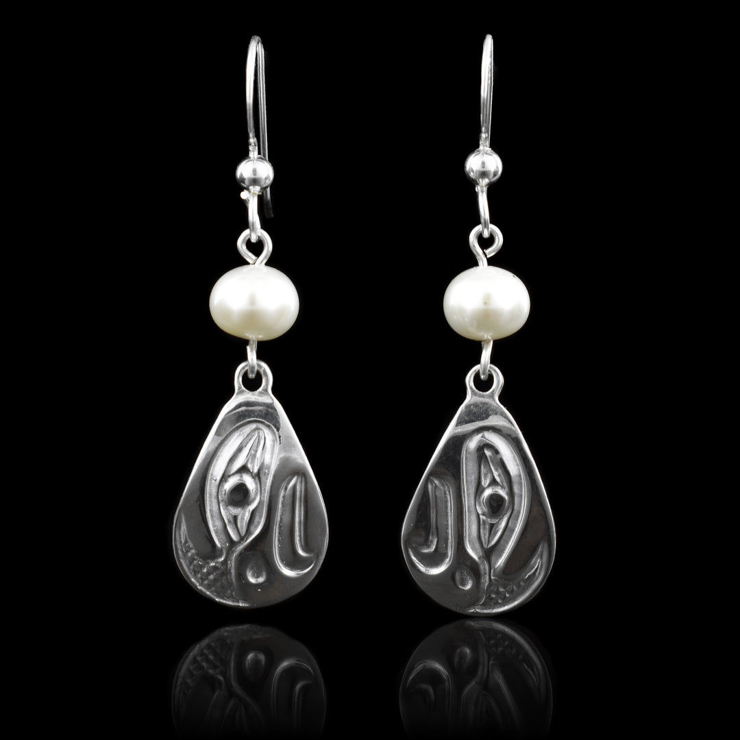 These elegant earrings feature a hand-carved eagle design in sterling silver, Pearl Teardrop Earrings. Each earring is accented with a genuine white pearl above the carving, adding a soft, natural shine that pairs beautifully with the polished silver.