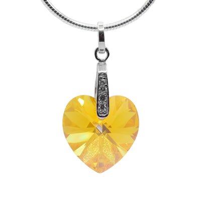 This yellow Swarovski crystal heart pendant has a heart shaped crystal hanging from sterling silver bail. There are cubic zirconia gems embedded into the bail.