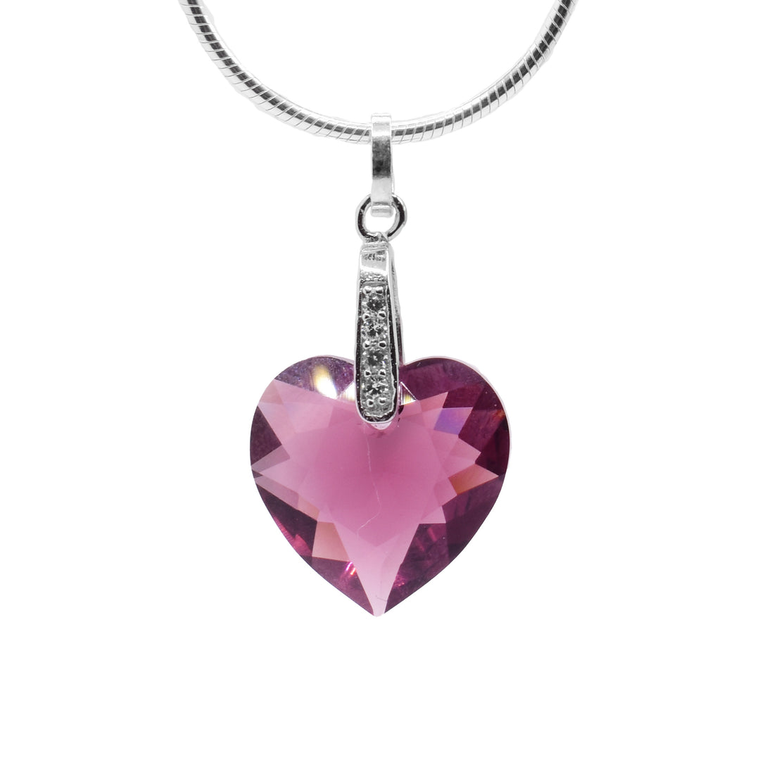 This amethyst Swarovski crystal heart pendant has a heart shaped crystal hanging from sterling silver bail. There are cubic zirconia gems embedded into the bail.
