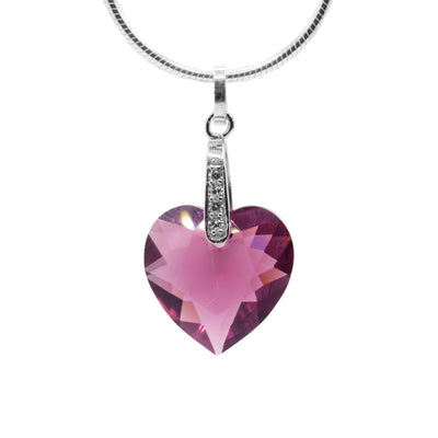 This amethyst Swarovski crystal heart pendant has a heart shaped crystal hanging from sterling silver bail. There are cubic zirconia gems embedded into the bail.