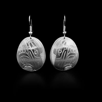 Domed, oval sterling silver earrings with ravens facing downwards. Cross-hatching background. Dangle earrings hand-carved by Coast Salish artist Travis Henry.