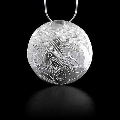 This sterling silver pendant is circle shaped and has the Hummingbird carved into it