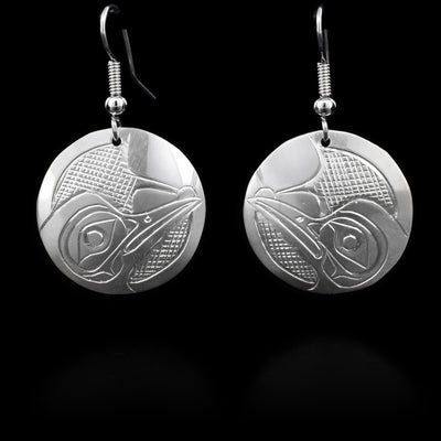 Sterling silver dangle earrings that have a round hang. The hang depicts the face of the Hummingbird.