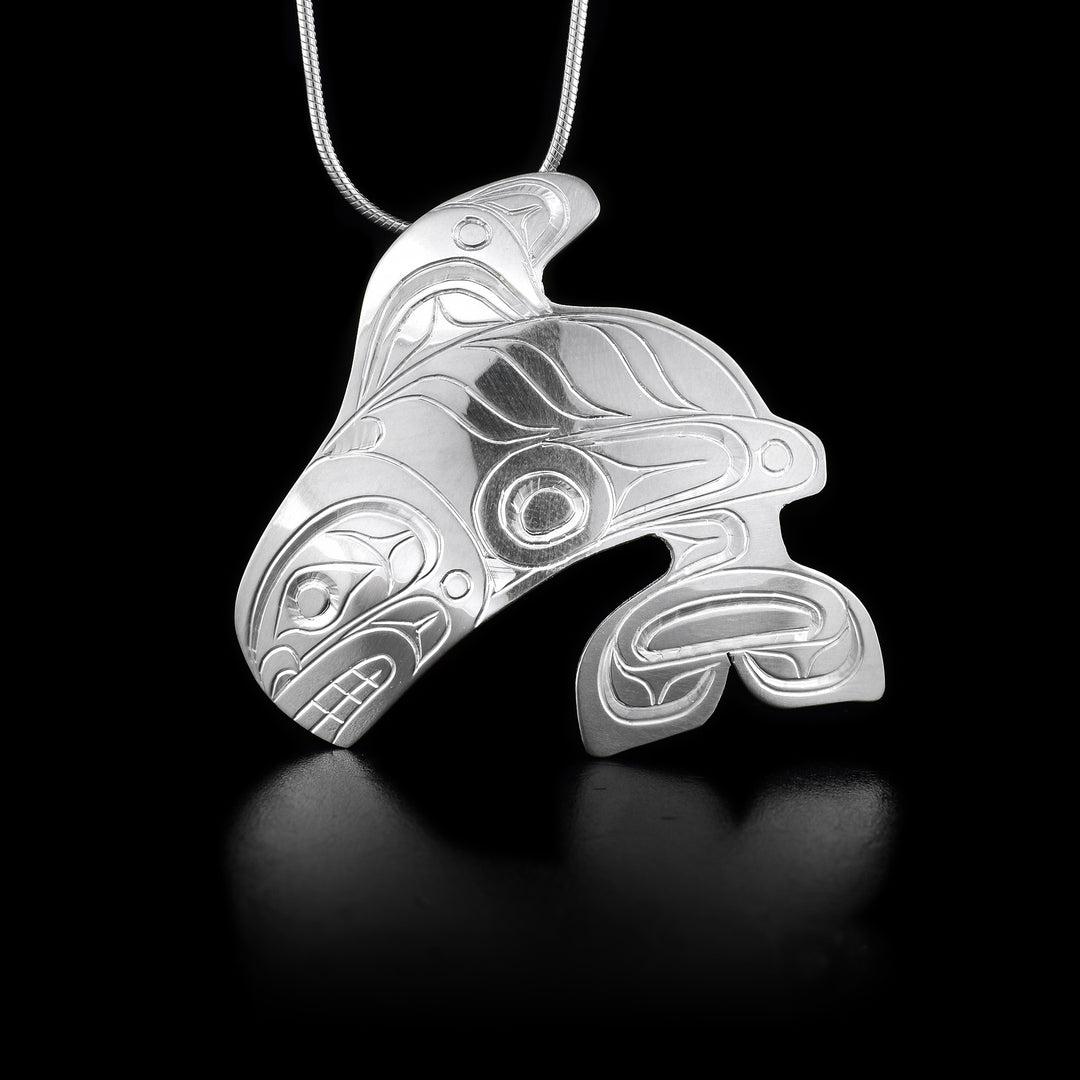 This sterling silver, Orca whale pendant is shaped like the Orca and has engravings that depict the Orca on it.