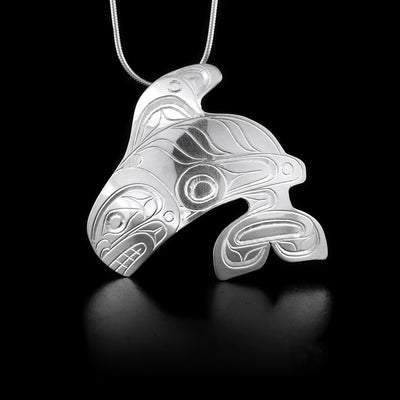 This sterling silver pendant is shaped like the Orca and has engravings that depict the Orca on it.