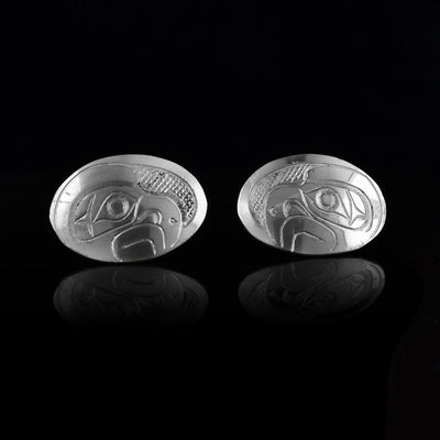 These Eagle stud earrings are made from sterling silver and have la, horizontal and oval shaped surfaces. There are depictions of the side profile of the head of the Eagle legend carved into the earrings. In the space behind the Eagle head, there are cross hatching designs.