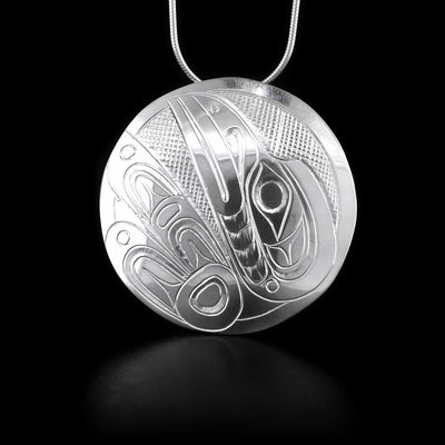 This sterling silver circle pendant has the Raven carved into it.