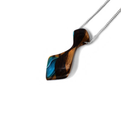 Blue side of pendant. Tie-shaped pendant made of wood with black stripes. Shimmering blue designs on top and bottom. Sterling silver chain included.