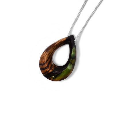 Green side of pendant. Wooden teardrop with cut-out center. Black stripe down center of pendant. Wood on left-hand side of stripe, shimmering green painted design on other.