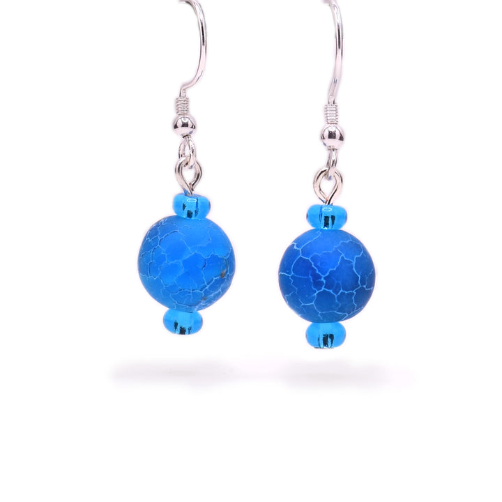 Round, blue dyed agate beads with cracked appearance and little blue glass beads above and below. Sterling silver hooks.