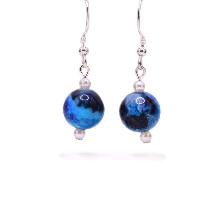 Round, blue and black dyed agate beads with little white pearl beads above and below. Sterling silver hooks.