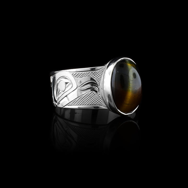 This sterling silver Eagle ring hand-carved by Tlingit artist Fred Myra. Featuring a bold cat's eye gemstone and the legend of the Eagle engraved on the band