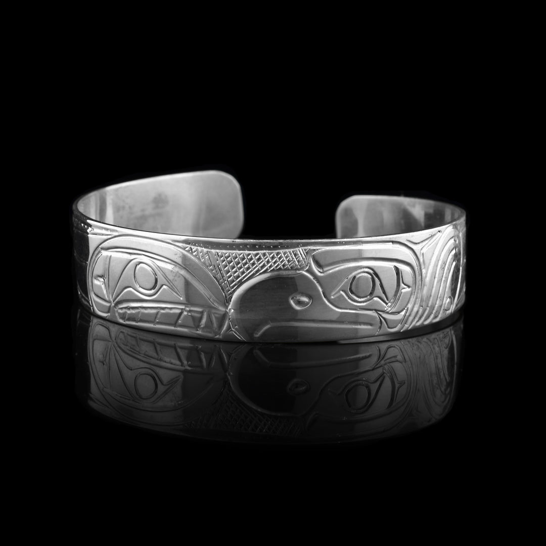 This sterling silver cuff is hand carved with the symbol of the eagle and orca.