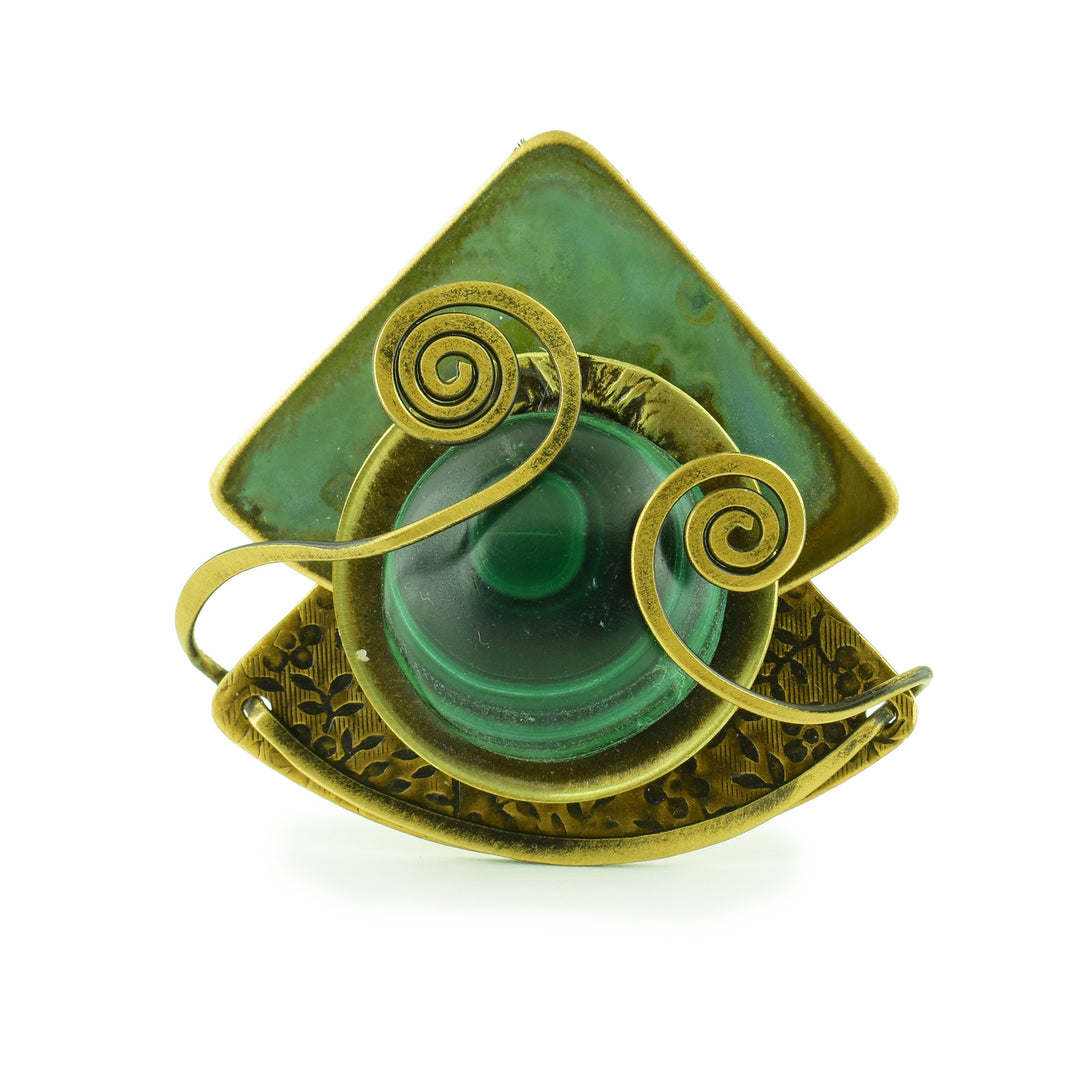 Elemental Green of Grace - two pieces of triangle brass forged together one textured the other one with a green coating and on to is a circular malachite gem held with two swirling pieces of brass to hold it there.