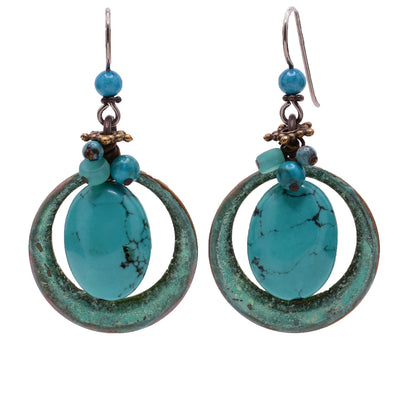 Dangle earrings made of turquoise, handworked brass, glass, and magnesite. Titanium hooks. By Honica.