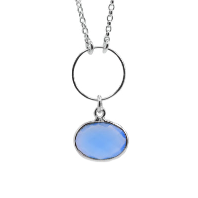 This crystal necklace is made from sterling silver and blue chalcedony crystal. The pendant is oval shaped and has a stunning blue crystal that dangles from a circle shaped silver hoop.