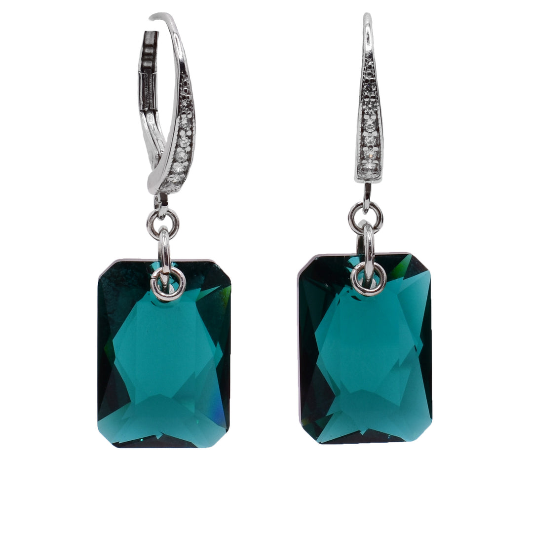 These green Swarovski crystal earrings have large, rectangle green crystal hangs. The crystals are emerald cut and dangle from the lever back hooks with sterling silver chain links. The lever back hooks display a row of cubic zirconia gems.