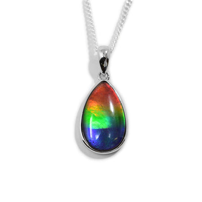 This ammolite pendant is made form sterling silver and ammolite gemstone and has a teardrop shape. The gem is teardrop shaped, raised and set onto a silver back.