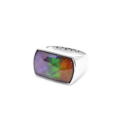 This chunky ammolite ring has a single sterling silver band that widens into a rectangular signet at the top. There is a large, beautifully cut ammolite gemstone set into the signet.