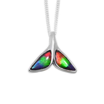 This whale tail pendant is made from sterling silver and ammolite gemstones and is shaped like a whale tail. There are ammolite gemstones set onto the fins of the tail.