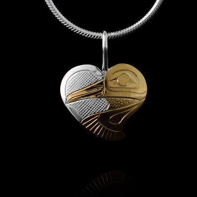 This Sterling Silver and gold heart pendant is half gold and half silver. There is a depiction of the Hummingbird carved into the piece and done using the gold plating.