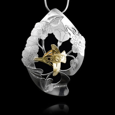 This gorgeous Hummingbird pendant is made from sterling silver and 14K gold. There is a diamond shaped silver section that has carvings of hibiscus flowers on it. There is a Hummingbird made from the gold mounted in the middle of the silver pendant.