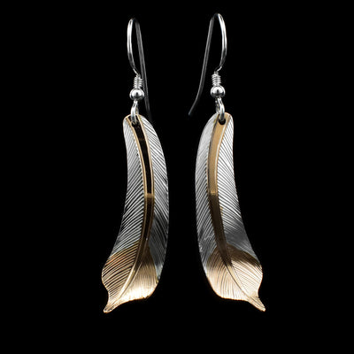 These dangling feather drop earrings have hangs that are thin, feather shaped and have intricate carved details on the surface of it. There is 18K gold plating on the center part of the feather and at the bottom.