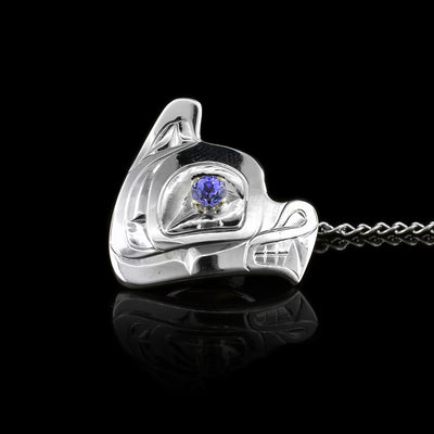 This Wolf tie pin is sterling silver and has been shaped and carved into the shape of the head of the Wolf. There is a purple colored tanzanite gem held in 14K gold and set in the eye of the legend.