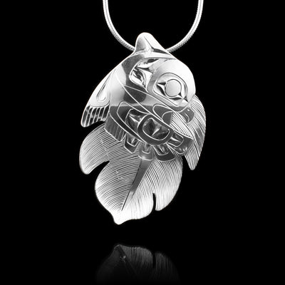 This Owl pendant is made from sterling silver and is shaped like the Owl and a feather. There are carvings on the surface of the pendant, half depicting a feather and the other half depicting the Owl.