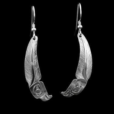 These sterling silver feather earrings are long and have depiction of the head of the Eagle carved into the bottom of them. The rest of the hangs are curved slightly and have carvings depicting a large feather.