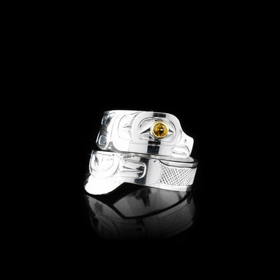 This Eagle ring has a sterling silver wide band that wraps around the finger twice. The top band  is carved to depict the head of the Eagle and the bottom one depicts its wing. There is a citrine gem that is embedded into the eye of the legend.