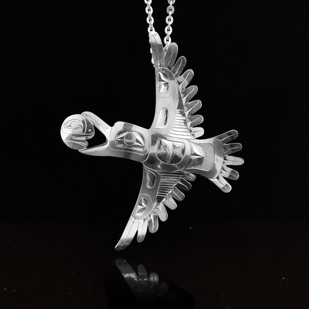 This Moon and Raven pendant is made from sterling silver. The pendant depicts the Raven carrying the Moon in its mouth while in flight. The piece is shaped like and has carvings on the surface of it that depict the Legends.