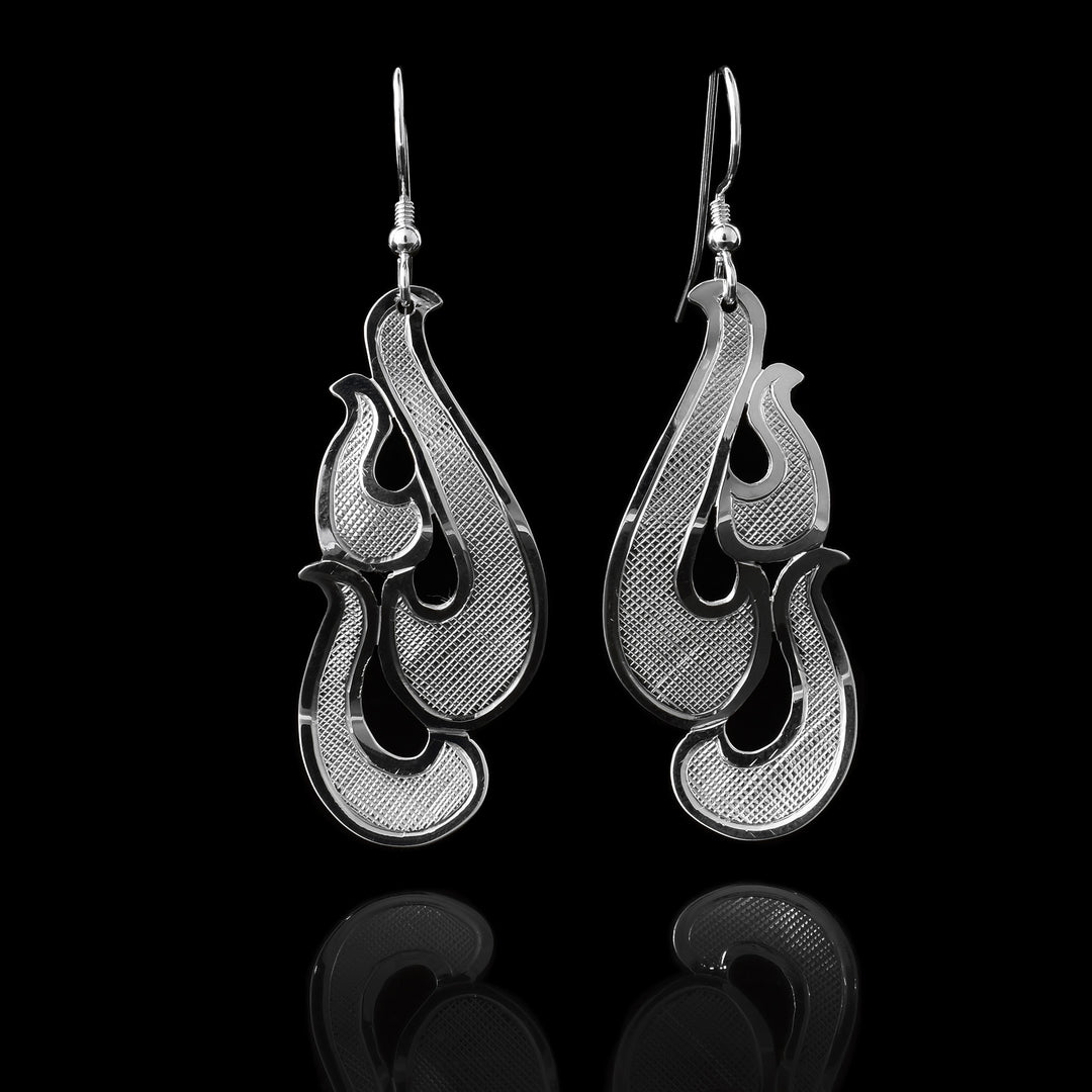 These sterling silver dangle earrings have hangs consisting of several pieces giving the piece a 3-D look. There are carvings on the surface of the piece giving giving it an interresting look.