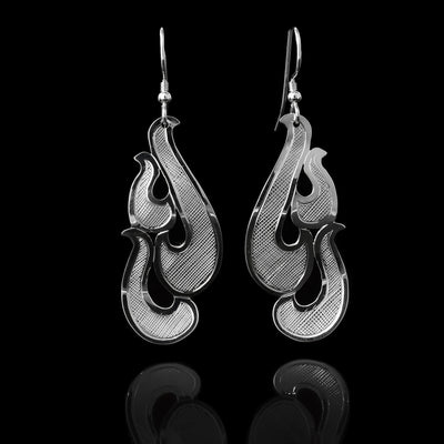 These sterling silver dangle earrings have hangs consisting of several pieces giving the piece a 3-D look. There are carvings on the surface of the piece giving giving it an interresting look.