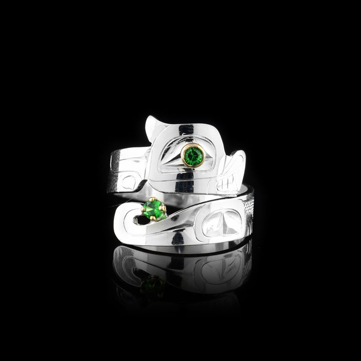 This Otter ring has a wide band that wraps around the finger twice. The top band is carved to depict the head of the Otter and the bottom one depicts its tail. There are green tsavorite gems that are embedded into the eye of the legend and in the center of its tail. There are 14K gold highlights around the eye of the Otter.