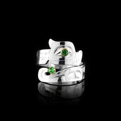 This Otter ring has a wide band that wraps around the finger twice. The top band is carved to depict the head of the Otter and the bottom one depicts its tail. There are green tsavorite gems that are embedded into the eye of the legend and in the center of its tail. There are 14K gold highlights around the eye of the Otter.