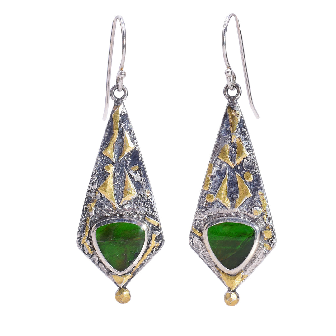 These sterling silver dangle earrings have long, diamond shaped hangs with a textured surface. On the hangs are 24K gold designs and triangular ammolite gems.