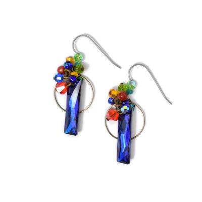Both earrings are a long, blue, baguette-cut Swarovski crystal with a brass hoop behind. A cluster of beads made of Swarovski crystal, carnelian agate, mother of pearl and glass adorn the top. Titanium hooks.