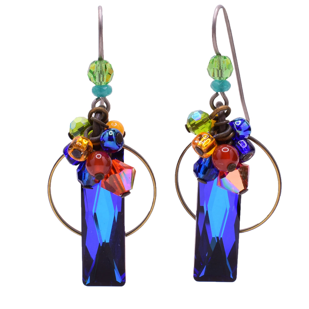 Dangle earrings made of carnelian agate, Swarovski crystal, lampworked glass, Mother of Pearl, handworked brass, and glass. Titanium hooks. By Honica.