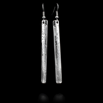 These sterling silver dangle earrings have long, thin, rectangular hangs with depictions of the Eagle carved into the surface of them.