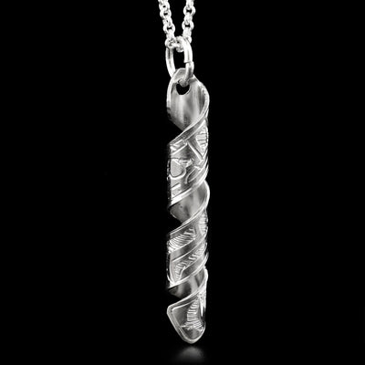 This pendant is made out of a sterling silver strip which has the face and body of the Bear carved on it and then coiled into a spiral.