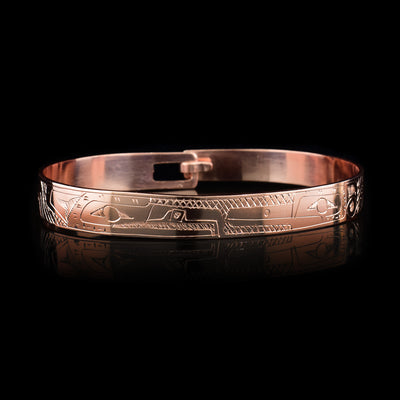 This copper bangle bracelet has a single, thin band with a simple hook clasp in the back. There is a depiction of the Hummingbird and the Eagle that have been beautifully carved into the surface of the band. The heads of the legends meet and are facing each other at the top f the band.