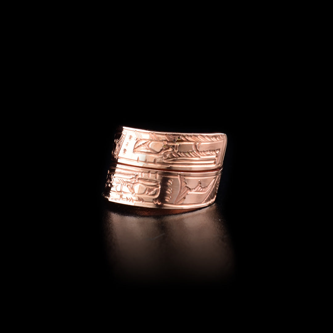 This copper ring has a band that wraps around the finger twice. There are depictions of the Eagle and the Raven carved into the surface of it. 
