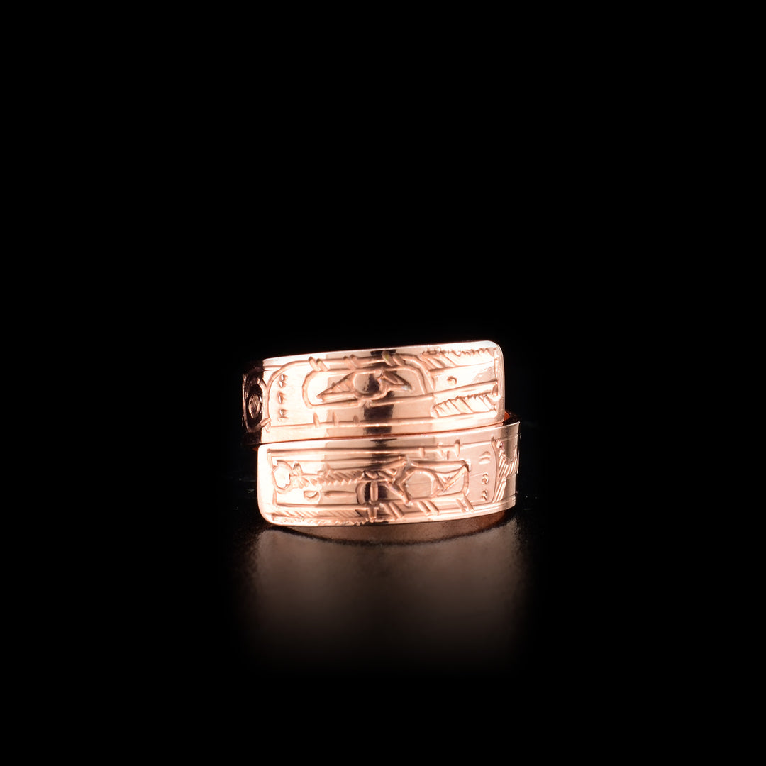 This copper ring has a band that wraps around the finger twice. There are depictions of the Hummingbird and the Raven carved into the surface of the band.