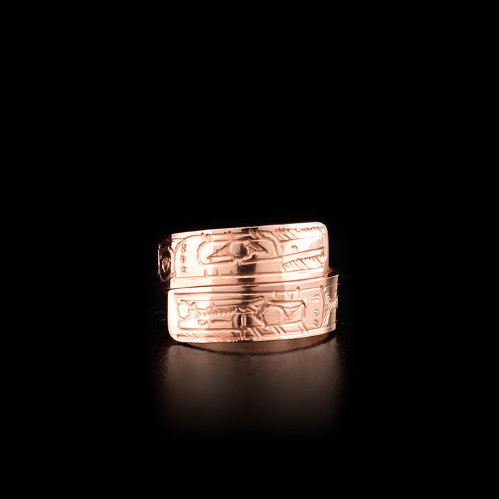 This copper ring has a band that wraps around the finger twice. There are depictions of the Hummingbird and the Raven carved into the surface of the band.